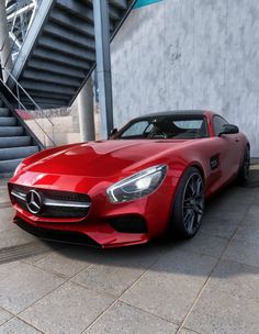 a red mercedes sports car parked in front of stairs