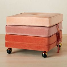 a pink and orange ottoman sitting on top of a wooden floor