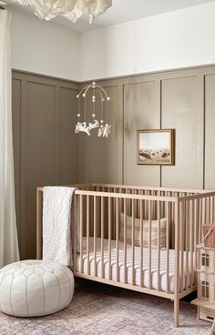 a baby's room with a white crib and chandelier hanging from the ceiling