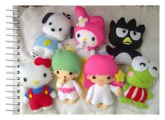 a group of hello kitty stuffed animals sitting next to each other on a white blanket