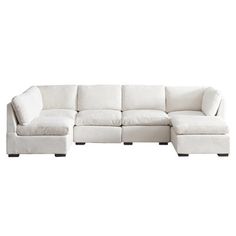 a white sectional couch sitting on top of a white floor next to a wooden table