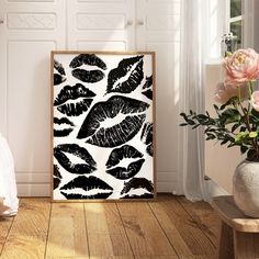 a black and white painting on the wall next to a vase with flowers in it