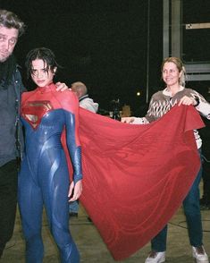 three people dressed up as superman and wonder woman pose for the camera with their arms around each other
