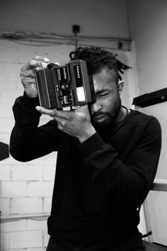 a man holding an old fashioned camera up to his face