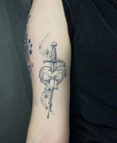 a person with a tattoo on their arm holding a knife and bow in the other hand