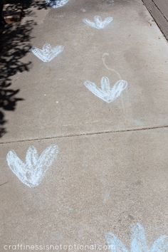 the sidewalk is painted with white chalk and has flowers drawn on it