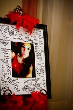 a photo frame with red feathers and writing on it