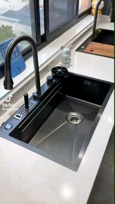 a kitchen sink sitting under a window next to a counter top with a faucet