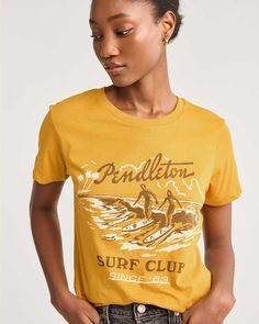 Made from soft 100% cotton, featuring a vintage-inspired graphic of a west-coast surf session. 100% cotton. Imported. | WOMEN'S SURF CLUB GRAPHIC TEE Pool Shirts, Vintage Shirt Design, Camping Tee, Surf Club, Surf Tee, Summer Graphic Tee, Vintage Boats, Surf Shirt, Retro Graphic Tees