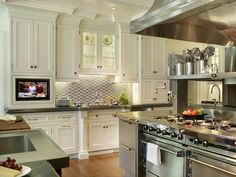 a large kitchen with white cabinets and stainless steel appliances, including an oven and microwave