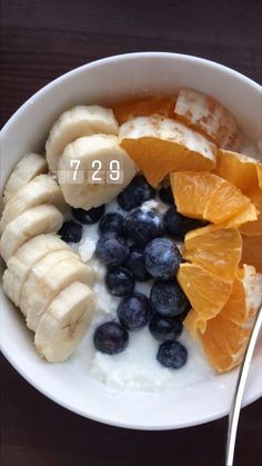 a bowl filled with yogurt, bananas and blueberries