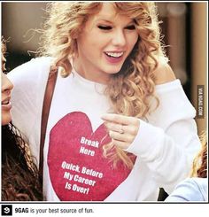 two young women are looking at a cell phone and one is wearing a heart t - shirt