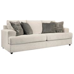 a white couch with some pillows on it's back and one pillow in the middle