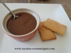 there is a bowl of chocolate and two pieces of bread on the plate