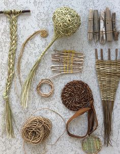 several different types of woven items laid out on a table with sticks and yarns