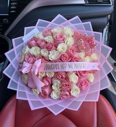 pink and white roses are in the center of a car bouquet with a tiara