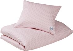 a pink bed with two pillows and a pillow on the bottom one is folded up