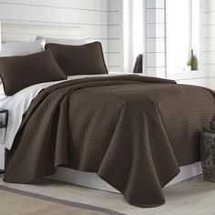 a bed with a brown bedspread and pillows