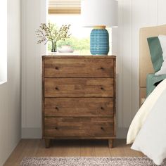 a bedroom scene with focus on the dresser and bed side table in the foreground