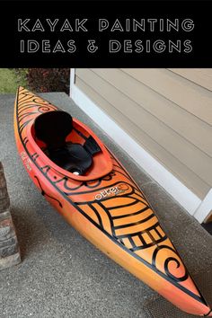 an orange kayak sitting on the ground next to a house