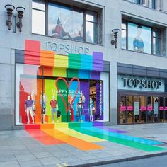 a rainbow colored store front with lots of windows