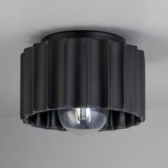 a black ceiling light with two lights on it's sides and an object hanging from the ceiling