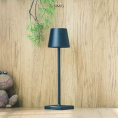 a lamp sitting on top of a wooden table next to a teddy bear