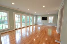 an empty living room with hard wood floors and large windows in the wall between them