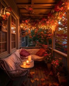 the porch is decorated with fall leaves and lit candles