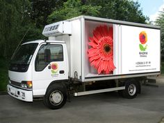 a white truck with a red flower on the back