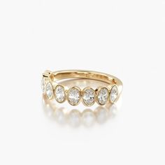 a yellow gold ring with five diamonds on the inside and outside, set against a white background