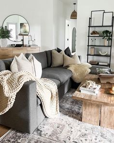 a living room filled with lots of furniture and pillows on top of a wooden table