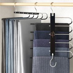 a rack with several different colored pants hanging from it