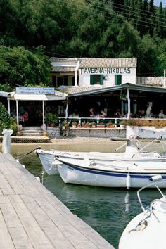 two boats are docked in front of a restaurant