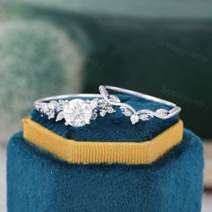 a diamond ring on top of a blue velvet box