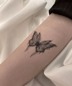 a small butterfly tattoo on the arm