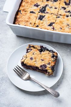 a piece of blueberry crumb cake on a plate with a fork next to it