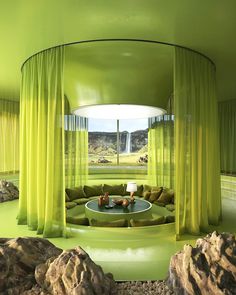 a living room filled with lots of green furniture