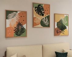 three paintings hang on the wall above a couch