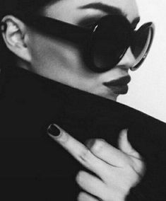 a woman with dark nails and black sunglasses