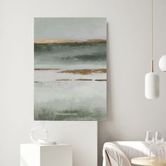 an abstract painting hangs on the wall above a dining room table with white chairs and a glass vase