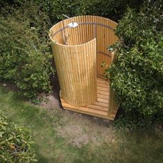 a wooden sauna in the middle of some bushes
