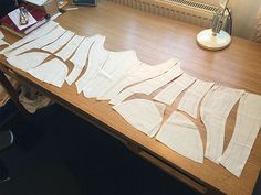 a wooden table topped with lots of cut out pieces of paper on top of it