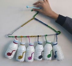 a child's hand is holding a string made out of plastic bottles