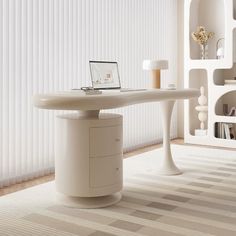 a laptop computer sitting on top of a desk in front of a white wall with vertical blinds