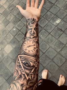 a man's arm with an all seeing eye tattoo on it and his hand