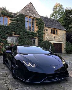 a black sports car parked in front of a house