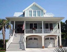 a large white house with two garages and stairs