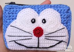 a crocheted coin purse with a cat's face painted on the front