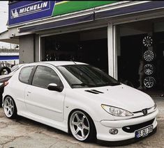 a white car parked in front of a building